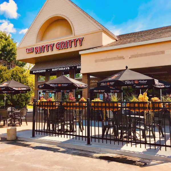 A restaurant with tables and chairs in front of it.