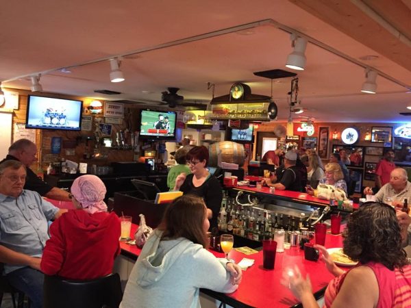 A group of people sitting at a bar.