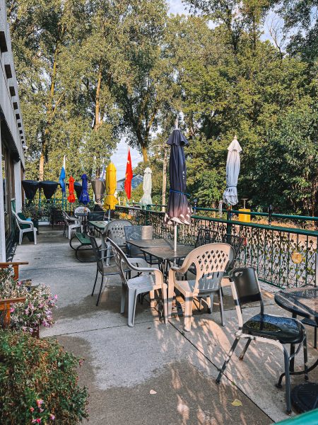 A patio with tables and chairs and umbrellas.