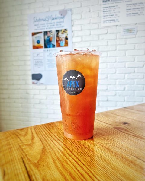 A glass of iced tea sitting on a wooden table.