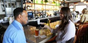 a man and a woman sitting at a bar