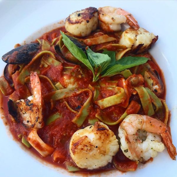 A plate of pasta with shrimp and clams.
