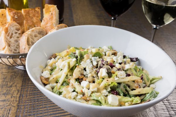 A bowl of salad and wine.