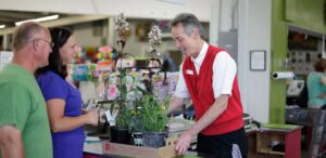 two men and a woman are shopping for plants