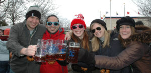 a group of people holding up glasses of beer