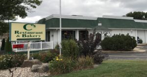 a green and white building with a sign for a restaurant and bakery