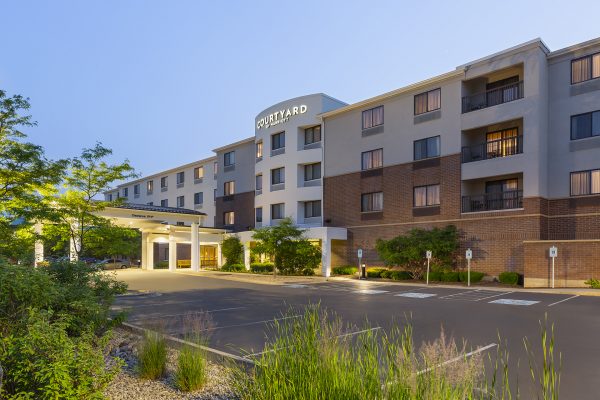 A courtyard by marriott in a parking lot at dusk.