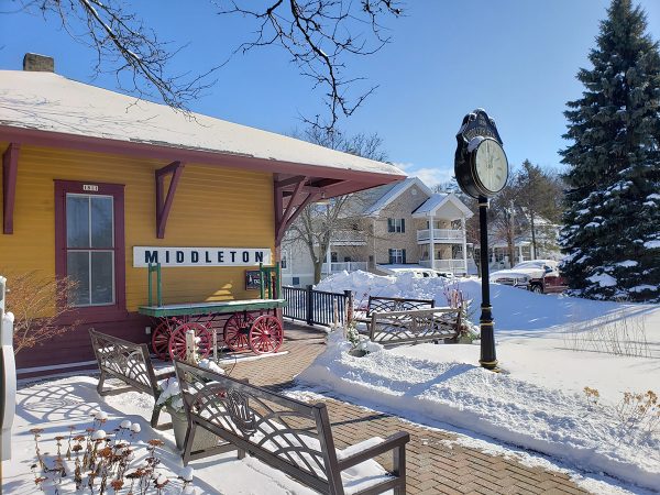 Photo of the Middleton depot station in winter, snow covering ground, green wagon and "Middleton" sign in view.