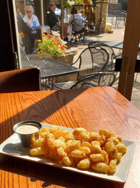A plate of french fries on a wooden table.