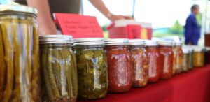 a row of jars filled with pickles on a table