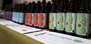 a row of bottles of apple cider sitting on a table
