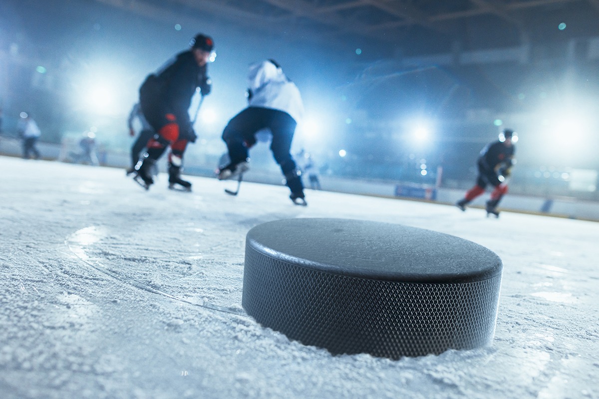 a hockey puck sits on the ice in front of a group of players