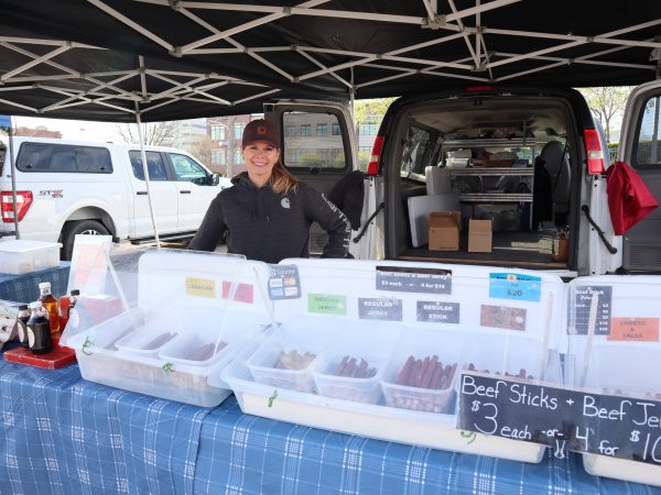 a woman standing in front of a food truck.
