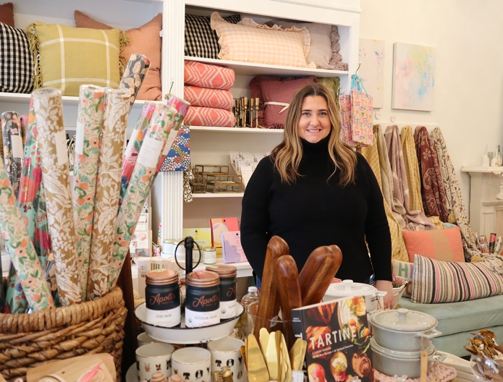 a woman standing in front of a display of items.