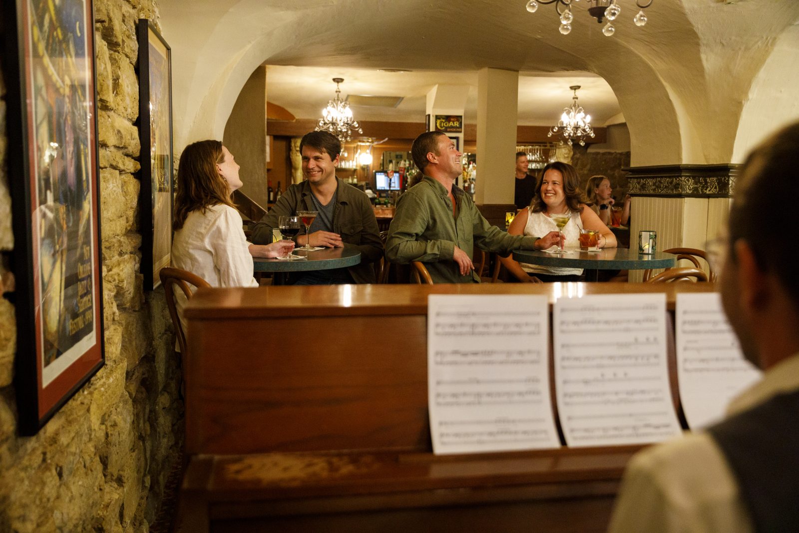 A group of people sitting around a piano.