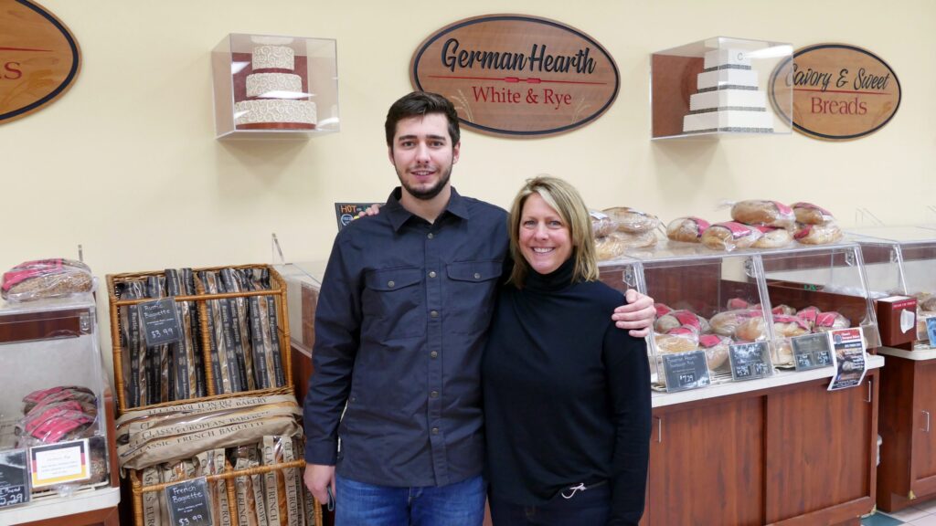 a man and a woman standing in front of a bakery
