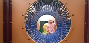 a little girl standing in front of a mirror