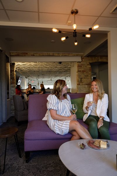 Two women sitting on a purple couch.