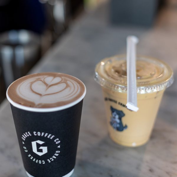 Two cups of coffee on a table next to each other.