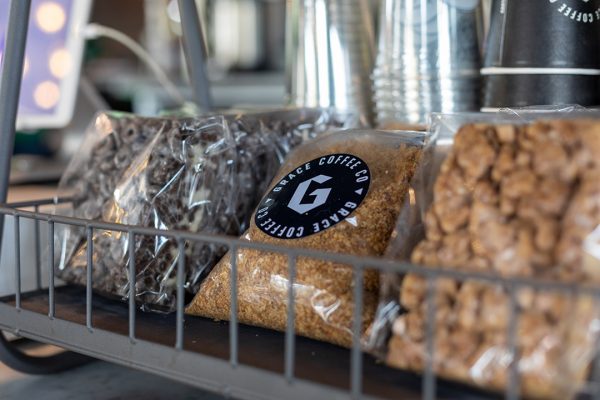 A coffee shop with a variety of snacks on a rack.