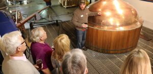 a group of people standing around a wooden barrel