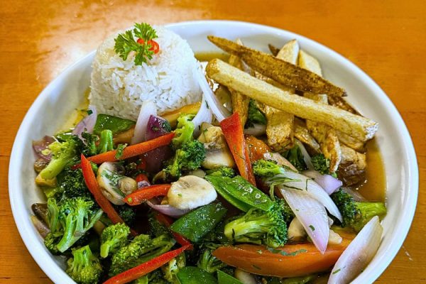 A plate of white rice, French fries, and sautéed mixed vegetables including broccoli, onions, bell peppers, and mushrooms, served on a white dish.