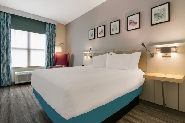 A hotel room with a bed and blue accents.