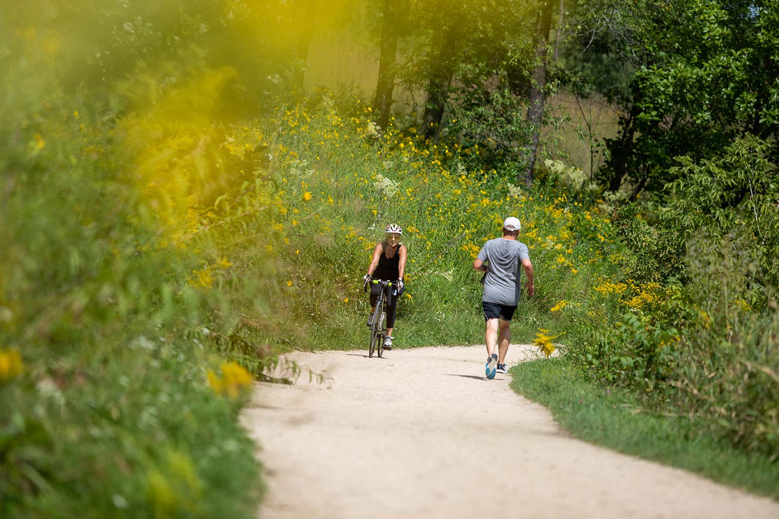 a couple of people riding bikes down a dirt road