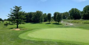 a golf course with a green and trees