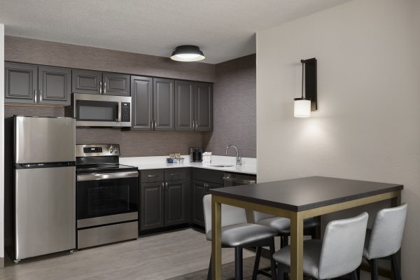 A kitchen with stainless steel appliances and a table.
