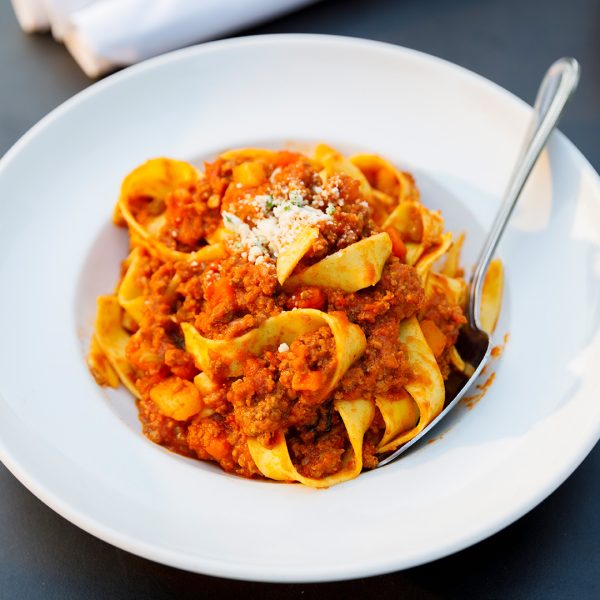 A plate of pasta with meat on it.