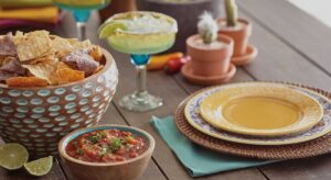 a wooden table topped with bowls of food and drinks